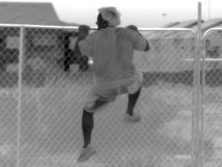 A thermal image from the Renegade thermal scope of a man scaling a fence