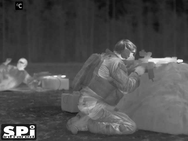 Immagine a infrarossi FLIR di un soldato al poligono di tiro con un cannocchiale termico sul suo fucile